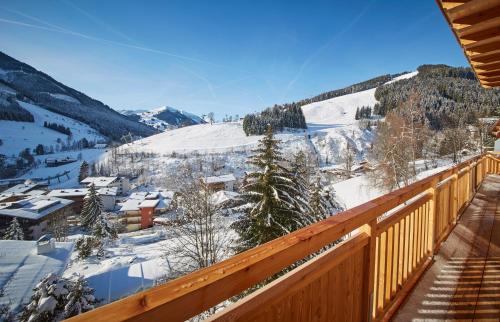 a view of a snowy mountain from a deck at AlpenParks Hotel & Apartment Sonnleiten in Saalbach Hinterglemm