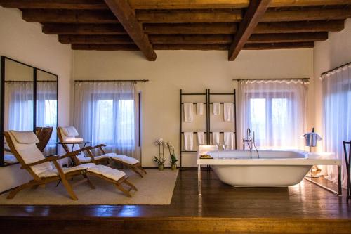 un ampio bagno con vasca e sedie a dondolo di Villa Ormaneto a Cerea