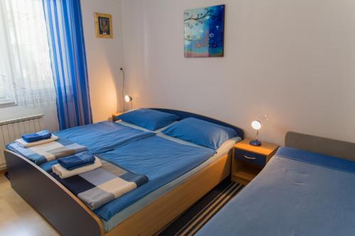 クランスカ・ゴーラにあるApartma Grošのベッドルーム1室(青いシーツと青い枕のベッド1台付)