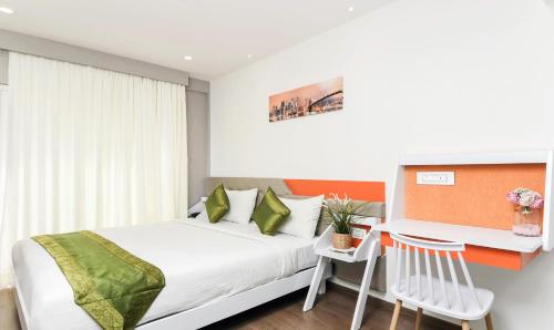 a bedroom with a bed and a desk with a chair at Treebo Stay Tuned JP Nagar in Bengaluru