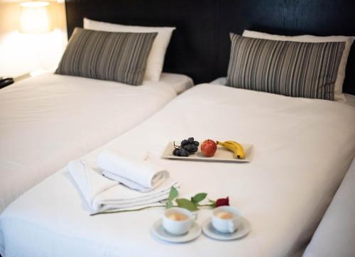 two beds with a tray of fruit and cups of coffee at St. Julian's Bay Hotel in St Julian's