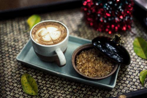 a cup of coffee on a plate with a bowl of food at Phor Liang Meun Terracotta Arts in Chiang Mai