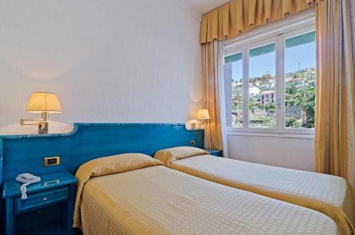two beds in a bedroom with a window at Hotel Ariston Montecarlo in Sanremo