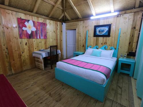 a bedroom with a bed and a table in a room at Moon Nest in Dhoāpālong