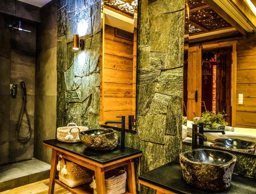 a bathroom with two sinks and a stone wall at Gold Hotel in Zakopane
