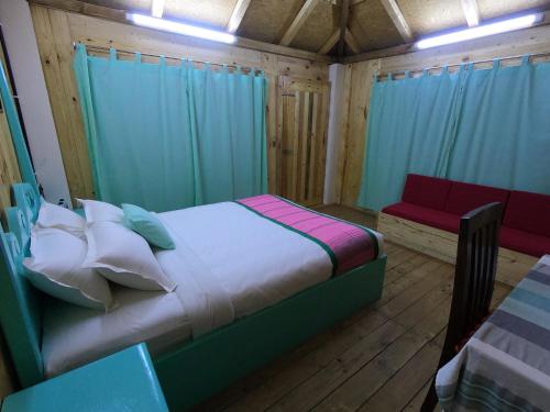a bedroom with a bed and a couch in it at Moon Nest in Dhoāpālong