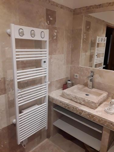 une salle de bain avec un lavabo et un miroir dans l'établissement Maison les pins, à Vedène