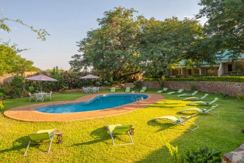 a yard with chairs and a swimming pool at Batonka Guest Lodge in Victoria Falls