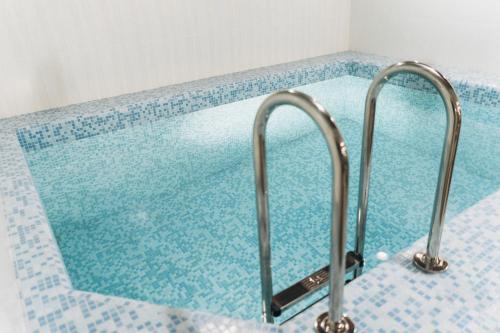 a swimming pool with two metal faucets at Hotel Asia in Abakan