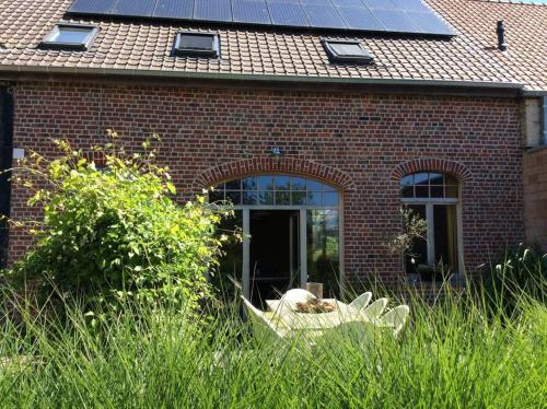 uma casa de tijolos com painéis solares no telhado em Kunstmin em Zandvoorde