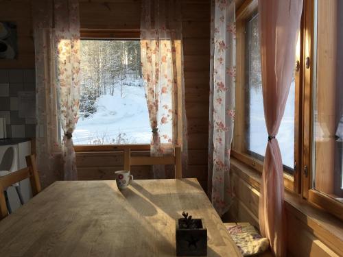 a room with a table and a window with a snow at Rautjärvi Cottage in Kokkola