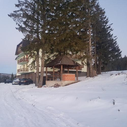 a building with a gazebo in the snow at 4 Seasons Vlašić Lux Apartments in Vlasic