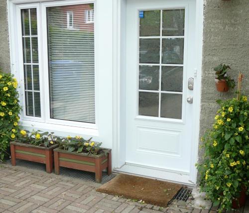 a white door with a bunch of plants sitting outside at B&B La Bedondaine in Quebec City