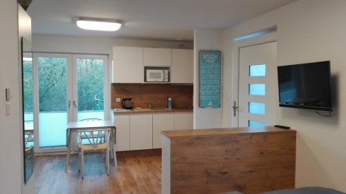 a kitchen and dining room with a table and a television at WeststrandPur in Norderney