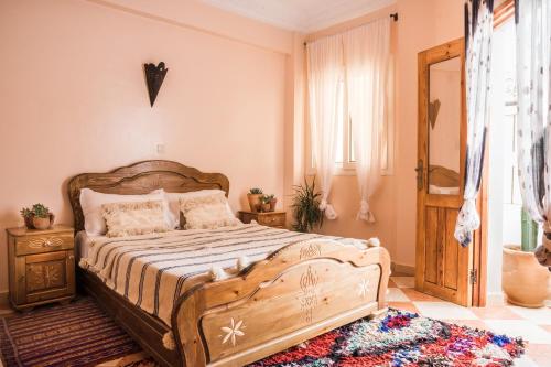 a bedroom with a wooden bed and a window at The Lunar Surf House in Tamraght Ouzdar