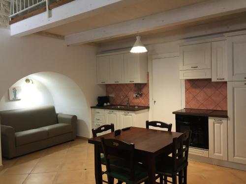 a kitchen and dining room with a table and a couch at La Ginestra Affittacamere in Ginosa