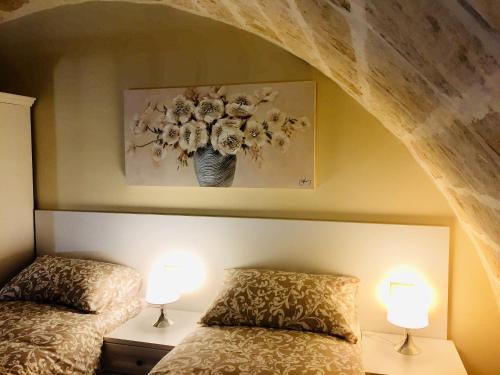 a bedroom with two beds and two lamps at La Ginestra Affittacamere in Ginosa