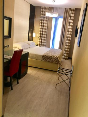 a bedroom with a bed and a desk and a chair at Best Western Cinemusic Hotel in Rome