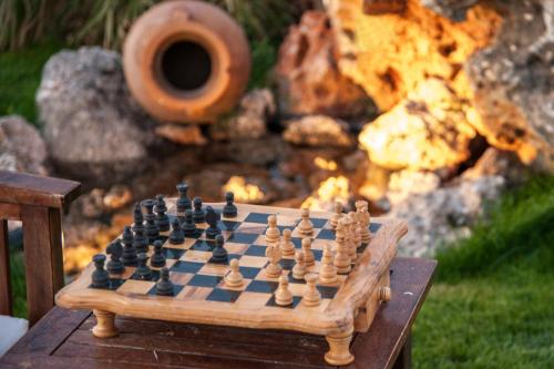 a chess board on a table in front of a fire at Villa Odyssia in Agios Nikolaos