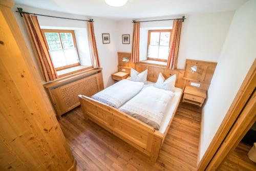een kleine slaapkamer met een bed en 2 ramen bij Ansitz Bergrichter in Cadipietra