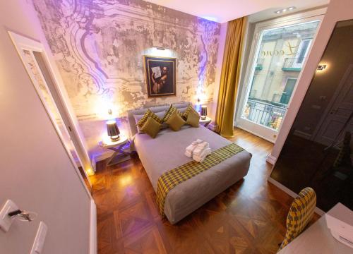 una camera con letto e divano di Leone Camere D'autore - CHIAIA a Napoli