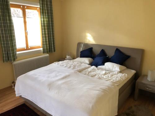 a large bed with blue pillows in a bedroom at Villa Loserblick in Altaussee