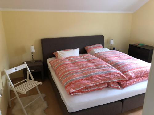 a bedroom with a bed with a blanket and a chair at Villa Loserblick in Altaussee