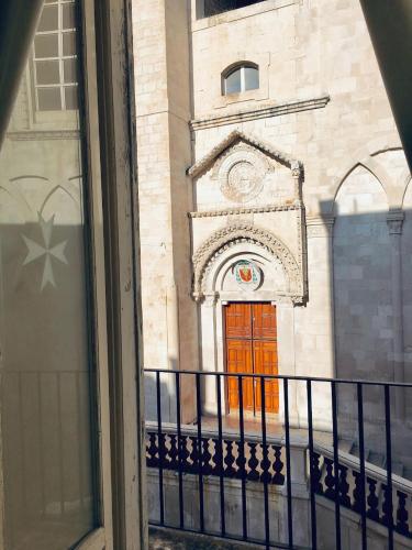 a view of a building with a orange door at Palazzo Framarino dei Malatesta - Noble Floor - XIV Century in Giovinazzo