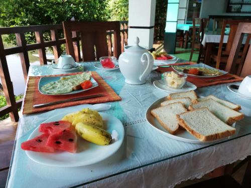 een tafel met borden brood en fruit erop bij Minuri Villa in Hikkaduwa