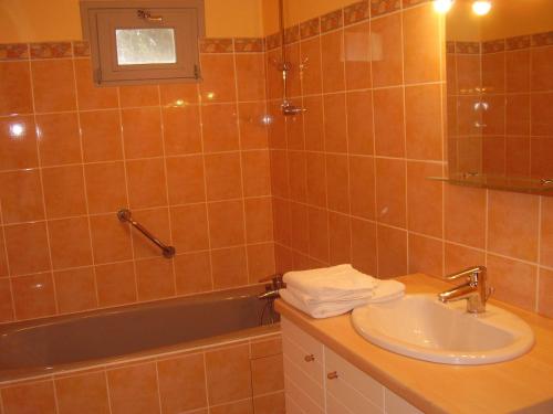 a bathroom with a sink and a bath tub at Logis Hôtel Restaurant Chez Nous in Sainte-Croix