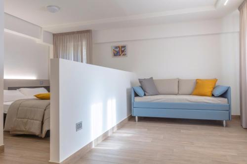 a bedroom with a blue couch and a bed at Hotel Miletto in San Massimo