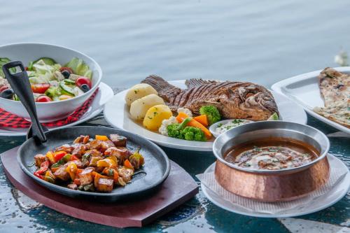 a table with plates of food and a bowl of soup at Hotel Tilapia in Mwanza