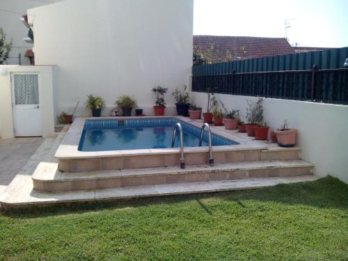 a backyard pool with a hot tub and stairs at Costa da Caparica Beach House in Costa da Caparica