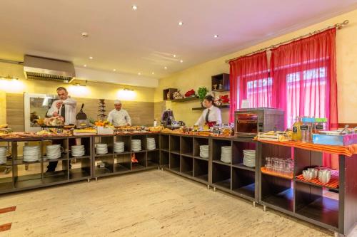 a group of people in a kitchen preparing food at Hotel Miletto in San Massimo
