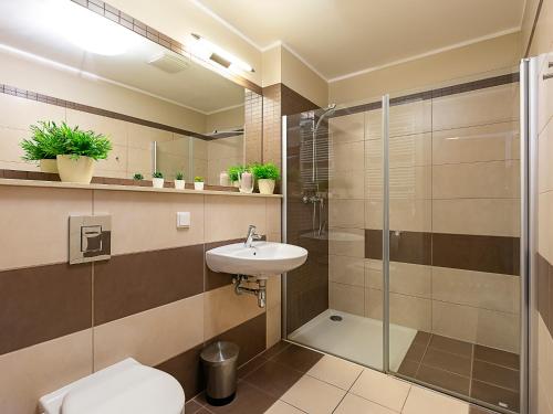 ein Badezimmer mit Dusche, Toilette und Waschbecken in der Unterkunft VacationClub - Olympic Park Apartment A405 in Kołobrzeg