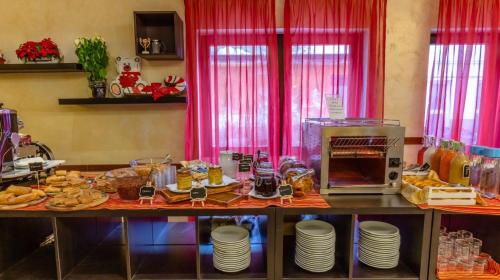 a table with food on it with pink curtains at Hotel Miletto in San Massimo