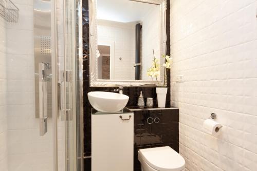 een badkamer met een wastafel, een toilet en een spiegel bij Rambla Poblenou&Mar Bella Beach in Barcelona