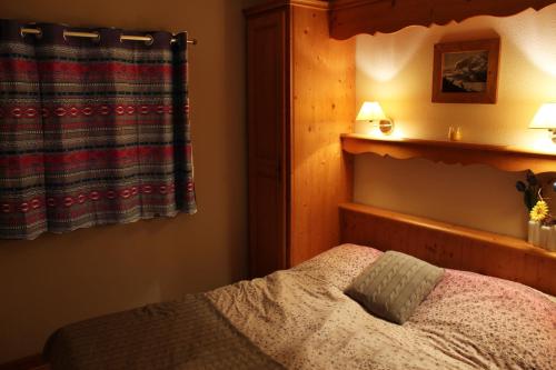 a bedroom with a bed and a window and a curtain at Les Chalets du Galibier II in Valloire