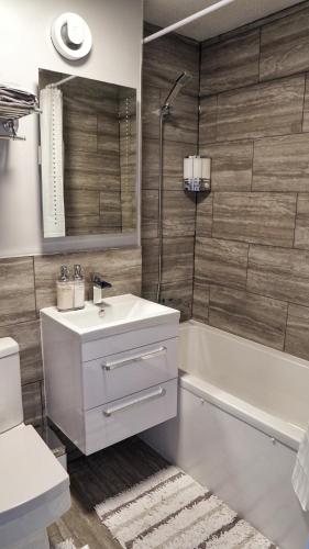 a bathroom with a sink and a tub and a toilet at North London Apartment - Edmonton in Edmonton