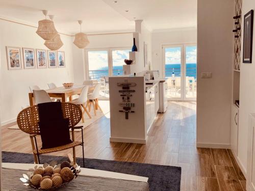 a kitchen and living room with a table and chairs at Sky & Sea in Sesimbra
