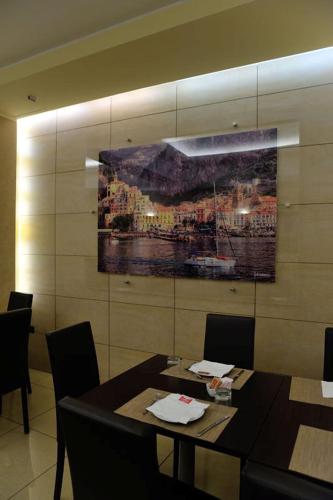 a dining room with a painting on the wall at Hotel Tiempo in Naples