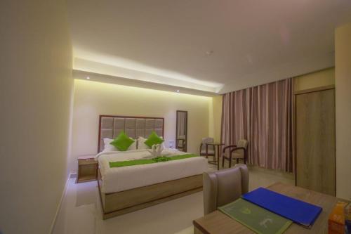 a hotel room with a large bed and a large window at Hotel Mira Garden in Sylhet