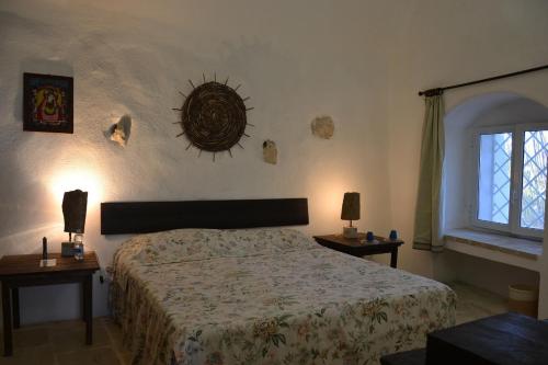 1 dormitorio con 1 cama, 2 mesas y una ventana en La Nave, en Gagliano del Capo