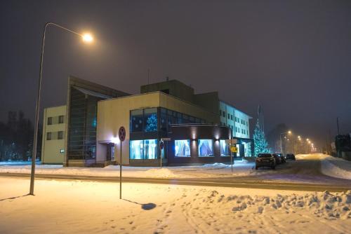a building on a street in the snow at night at Hotel Tigra in Priekuļi