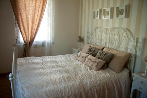 a bedroom with a white bed with pillows on it at Alle Falesie in Duino