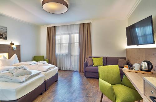 a hotel room with a bed and a couch at Hotel Lindenhof in Kellberg