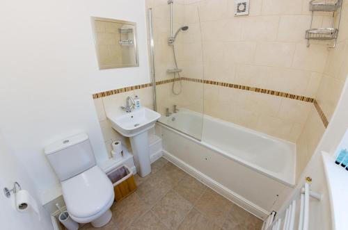 a bathroom with a toilet and a sink and a tub at 15 Saxon Road in Exeter