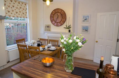 uma sala de jantar com uma mesa com um vaso de flores em 15 Saxon Road em Exeter