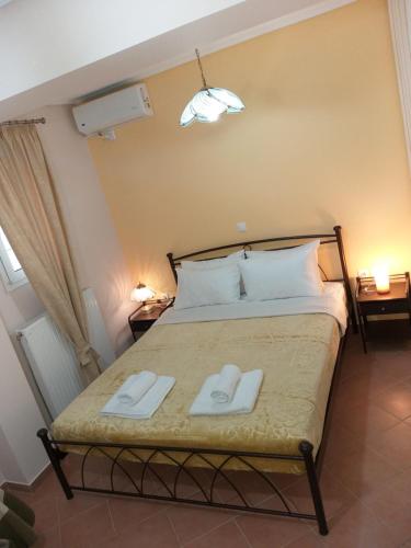 een slaapkamer met een bed met twee handdoeken erop bij HELEN in Artemida