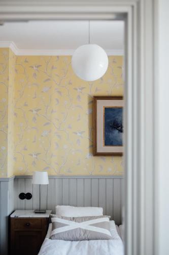 a bedroom with a bed and a pendant light at Kivikstrand Badhotell in Kivik
